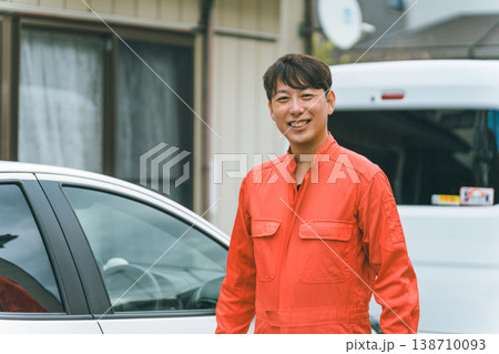 乗用車とツナギ姿の男性 138710093
