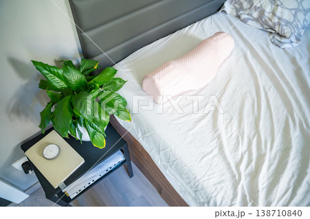 Ergonomic orthopedic pillow on bed in modern bedroom interior. Cervical support pillow for proper neck alignment, posture correction and comfortable healthy sleep at home 138710840