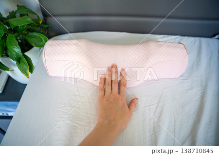 Point of view holding ergonomic orthopedic pillow over bed in bedroom. Choosing cervical support pillow for proper neck alignment, posture correction and comfortable healthy sleep at home. Point of view holding ergonomic orthopedic pillow over bed in bedroom. Choosing cervical support pillow for proper neck alignment, posture correction and comfortable healthy sleep at home. 138710845