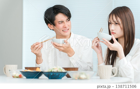 マイホームのダイニングテーブルで食事をする若いアジア人夫婦,カップル(不味い,マズい,味付け) マイホームのダイニングテーブルで食事をする若いアジア人夫婦,カップル(不味い,マズい,味付け) 138711506