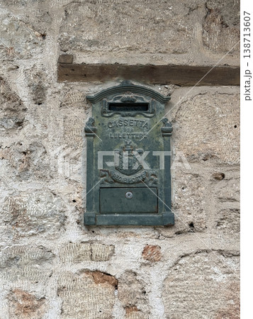 Vintage metal mailbox on rustic stone wall, suitable for backgrounds or historical themes 138713607