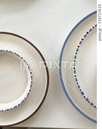 Ceramic plates with blue and brown rim on white background for dining or cooking concepts 138713619