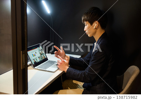 個室の集中ブースでオンライン会議に参加する外資系企業の若手男性SE 個室の集中ブースでオンライン会議に参加する外資系企業の若手男性SE 138715982