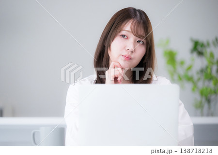 自宅でパソコンを使いながらタイピングする在宅勤務やリモート勤務や資格の勉強をする女性考える悩む迷う 自宅でパソコンを使いながらタイピングする在宅勤務やリモート勤務や資格の勉強をする女性考える悩む迷う 138718218