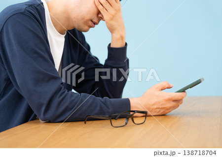 スマホを見て悩む男性 手元 横向き スマホを見て悩む男性 手元 横向き 138718704