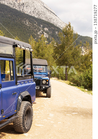 Land rover defenders parked on dirt road, exploring mountains 138719277