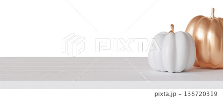 Two pumpkins in white and gold are placed on a tabletop. This setting shows a festive decoration for Halloween. The clear background highlights the pumpkins well Two pumpkins in white and gold are placed on a tabletop. This setting shows a festive decoration for Halloween. The clear background highlights the pumpkins well 138720319