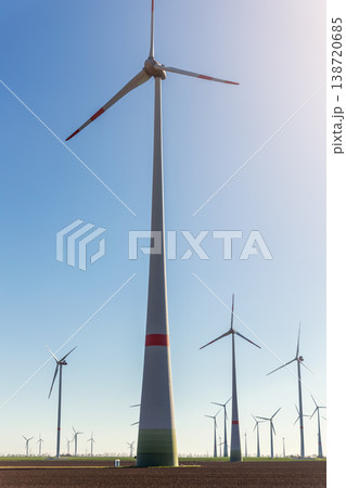 Wind turbines park agricultural field Germany clear blue sky produce renewable electricity. Wind farm landscape sustainability climate energy transition independence during European energy crisis Wind turbines park agricultural field Germany clear blue sky produce renewable electricity. Wind farm landscape sustainability climate energy transition independence during European energy crisis 138720685