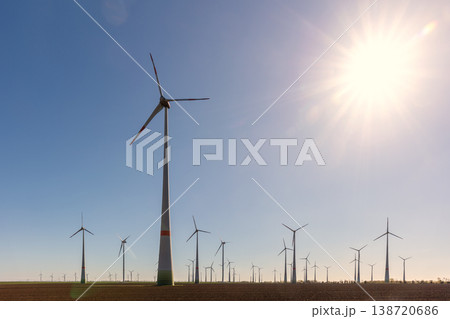 Wind turbines park agricultural field Germany clear blue sky produce renewable electricity. Wind farm landscape sustainability climate energy transition independence during European energy crisis 138720686