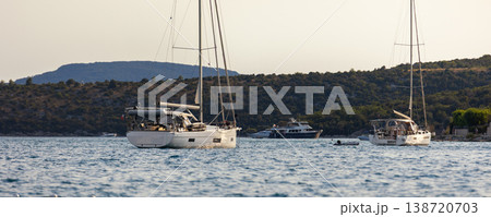 Sailboats anchored calm sea bay mediterranean coast green hills clear sky during warm summer evening. Scenic marine landscape yachts travel leisure atmosphere tranquil seaside tourism destination Sailboats anchored calm sea bay mediterranean coast green hills clear sky during warm summer evening. Scenic marine landscape yachts travel leisure atmosphere tranquil seaside tourism destination 138720703