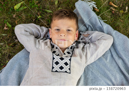 Relaxed Young Boy Lying On Blanket In Park Looking At Camera Summer Lifestyle Relaxed Young Boy Lying On Blanket In Park Looking At Camera Summer Lifestyle 138720963