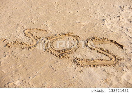 SOS Message Written On Sandy Beach Surface Emergency Help Concept Background SOS Message Written On Sandy Beach Surface Emergency Help Concept Background 138721481