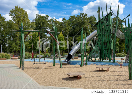 Creative Wooden Playground Structure With Slide And Swing In Urban Park On Sunny Day Creative Wooden Playground Structure With Slide And Swing In Urban Park On Sunny Day 138721513