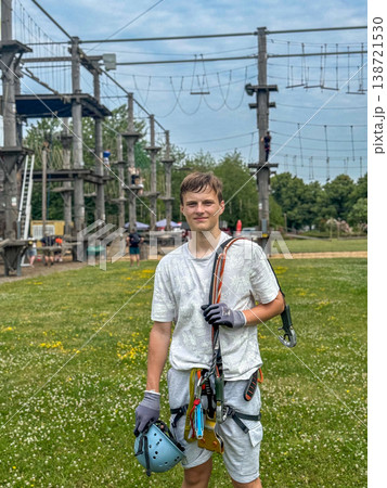 Teen Boy In Safety Harness Holding Helmet After Rope Adventure Park Climbing Activity Outdoor Extreme Sport Recreation 138721530