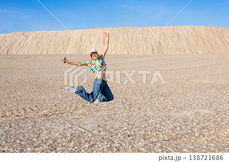 Young Woman Jumping On Salt Flat Landscape With Joyful Freedom And Summer Travel Energy 138721686