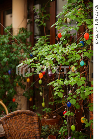 Colorful Easter Egg Decorations Hanging On Green Plant Branches At Cozy Outdoor Cafe Terrace Colorful Easter Egg Decorations Hanging On Green Plant Branches At Cozy Outdoor Cafe Terrace 138721726