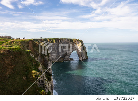 Etretat cliff arch with coastal grass and turquoise sea in Normandy France 138722017