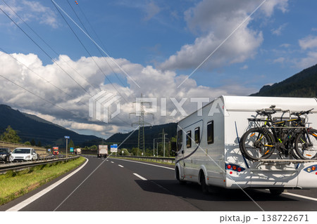 Scenic view big modern white family rv camper van vehicle drive Europe highway road alpine mountain blue sky summer day. Rving motorhome lifestyle travel and adventure tourism trip journey concept 138722671