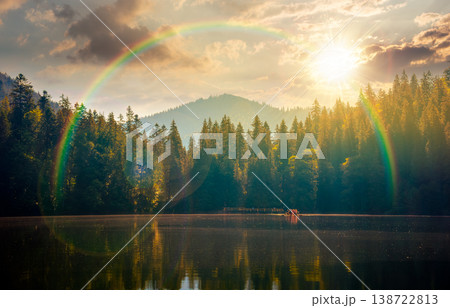 quiet sunset over lake. coniferous forest reflecting on the calm body of water. exquisite place in national park in evening light under rainbow. summer nature background image for nostalgia concept quiet sunset over lake. coniferous forest reflecting on the calm body of water. exquisite place in national park in evening light under rainbow. summer nature background image for nostalgia concept 138722813