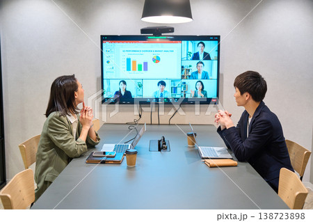 会議室の大型モニターでオンライン会議を行うIT企業の男女 会議室の大型モニターでオンライン会議を行うIT企業の男女 138723898