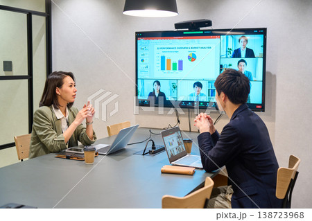会議室の大型モニターでオンライン会議を行うIT企業の男女 138723968