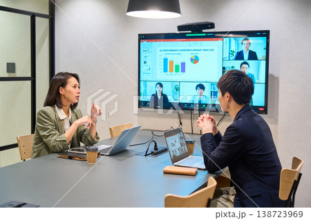 会議室の大型モニターでオンライン会議を行うIT企業の男女 138723969