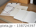 ノートと眼鏡とクリップボードを置いた机 138724397
