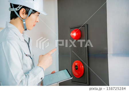 自動火災報知設備の点検をする作業着の男性 自動火災報知設備の点検をする作業着の男性 138725284