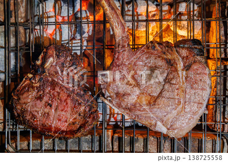 Tomahawk and T-bone steaks grilling top view Tomahawk and T-bone steaks grilling top view 138725558