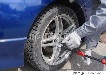 クロスレンチでホイールナットを緩めるタイヤ交換作業 138725652