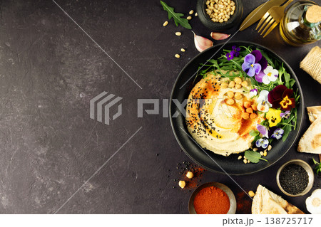 Gourmet Hummus with Edible Flowers and Spices on Dark Background 138725717
