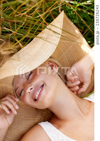 Woman, hat and relax on grass with peace, happiness and freedom in summer. Outdoor, fashion and girl lying on lawn with a smile on face for holiday, vacation or free time in nature with wellness Woman, hat and relax on grass with peace, happiness and freedom in summer. Outdoor, fashion and girl lying on lawn with a smile on face for holiday, vacation or free time in nature with wellness 138726243