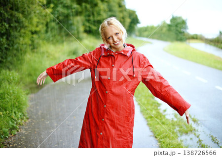 Woman, smile and raincoat in rain with arms, wet and cold from weather, winter and nature. Happy female person, fashion and red jacket in storm, rainfall and protection from water, face and outdoors Woman, smile and raincoat in rain with arms, wet and cold from weather, winter and nature. Happy female person, fashion and red jacket in storm, rainfall and protection from water, face and outdoors 138726566