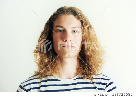 Long hair, man or fashion for portrait in a studio with hipster style clothing or shirt on white background. Face, person or headshot of young stylish gen z male model with cool confidence and pride Long hair, man or fashion for portrait in a studio with hipster style clothing or shirt on white background. Face, person or headshot of young stylish gen z male model with cool confidence and pride 138726580