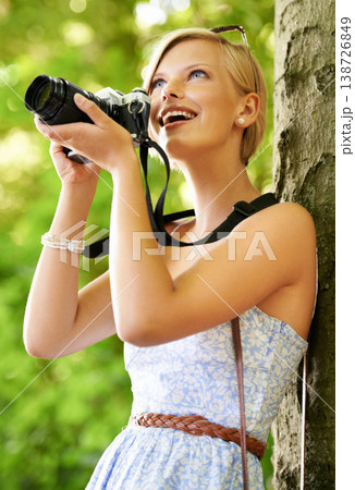 Happy, photographer and woman in nature with trees, camera and vacation in environment. Forest, park and girl shooting with natural happiness outdoor on summer holiday, trip or travel with technology 138726849