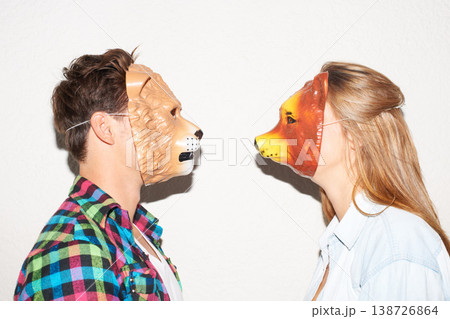 Animal mask, party and a couple on a white background for fun, bonding or comedy. Funny, character and a man and woman with equipment for a comic date, social or at a halloween event together 138726864