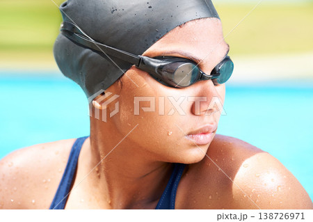Woman, face and athlete swimming with goggles in sunshine for challenge, underwater sports and training. Serious swimmer thinking in pool of performance, exercise and triathlon competition in summer 138726971