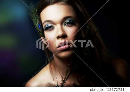Portrait, makeup and peacock feather with a woman in studio on dark background for natural skincare or wellness. Face, skin or beauty and a confident young model looking creative with cosmetics Portrait, makeup and peacock feather with a woman in studio on dark background for natural skincare or wellness. Face, skin or beauty and a confident young model looking creative with cosmetics 138727314