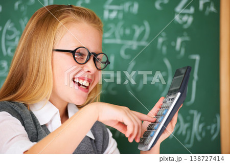 Child, calculator and happy for education, learning and problem solving or solution on chalkboard. Smart student, kid or girl with glasses and excited for school, typing numbers and math in classroom Child, calculator and happy for education, learning and problem solving or solution on chalkboard. Smart student, kid or girl with glasses and excited for school, typing numbers and math in classroom 138727414