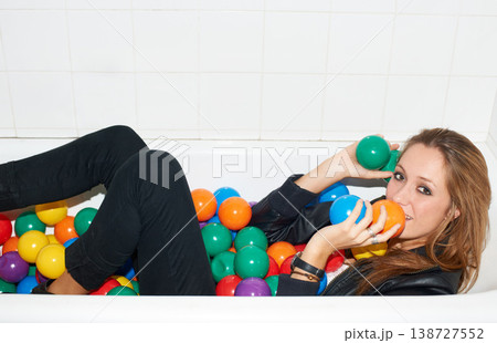 Portrait, balls and woman in bathtub for fashion, style and trendy hipster at home. Happy person in tub with color, party or plastic with body in bathroom, relax in edgy and cool clothes in Canada Portrait, balls and woman in bathtub for fashion, style and trendy hipster at home. Happy person in tub with color, party or plastic with body in bathroom, relax in edgy and cool clothes in Canada 138727552