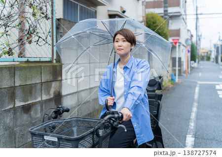 自転車に乗って傘をさす女性・交通違反 自転車に乗って傘をさす女性・交通違反 138727574