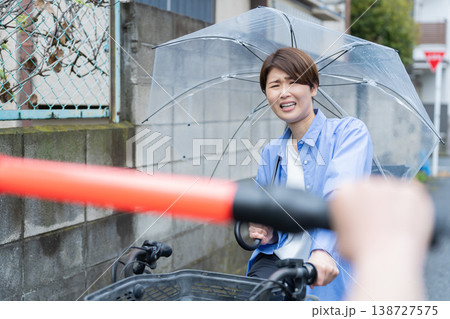 自転車に乗って傘をさす女性・交通違反 自転車に乗って傘をさす女性・交通違反 138727575