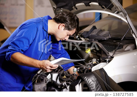 Car, service and repair with a mechanic man in a workshop as an engineer looking at the engine of a vehicle. Garage, report or quote with a young technician working under the hood of an automobile Car, service and repair with a mechanic man in a workshop as an engineer looking at the engine of a vehicle. Garage, report or quote with a young technician working under the hood of an automobile 138727585