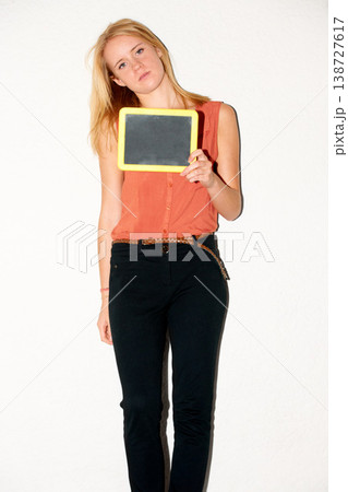 Portrait, mockup and girl in studio with blank, slate or black board for announcement on white background. Face, attitude or gen z female model with hand holding space for message, promo or news info 138727617