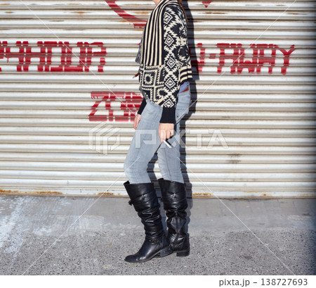 Boots, fashion and body of young woman by garage door for stylish, cool and edgy outfit with jeans. Legs, feet and zoom of female person with cigarette and trendy grungy style by steel background. Boots, fashion and body of young woman by garage door for stylish, cool and edgy outfit with jeans. Legs, feet and zoom of female person with cigarette and trendy grungy style by steel background. 138727693
