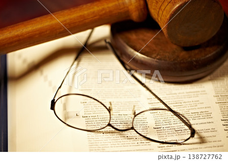 Table, law and a report, glasses and gavel for a court decision, notes or a justice report. Closeup, desk and paperwork or a dictionary for legal knowledge, courtroom words or a crime defense Table, law and a report, glasses and gavel for a court decision, notes or a justice report. Closeup, desk and paperwork or a dictionary for legal knowledge, courtroom words or a crime defense 138727762