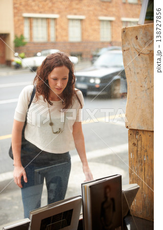Bookstore, window shopping and woman with sales, discount and customer with choice. City, town and sidewalk with a female person at shop and boutique for purchase, library and glass on urban road Bookstore, window shopping and woman with sales, discount and customer with choice. City, town and sidewalk with a female person at shop and boutique for purchase, library and glass on urban road 138727856