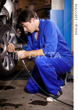 Mechanic, man and change wheel in shop, electric drill and car service or auto repairs for maintenance. Technician, male person and tire safety for automobile, rim and vehicle inspection in workshop Mechanic, man and change wheel in shop, electric drill and car service or auto repairs for maintenance. Technician, male person and tire safety for automobile, rim and vehicle inspection in workshop 138727916
