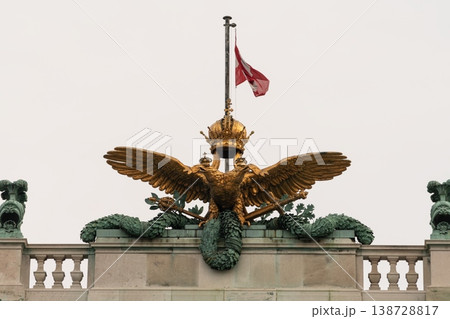 Golden double headed imperial eagle with crown atop Hofburg Palace in Vienna, Austria 138728817