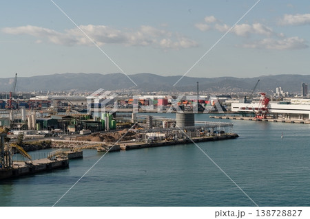 View of industrial waterfront in Port of Barcelona with cranes tanks container yards and harbor infrastructure. Barcelona, Spain 138728827